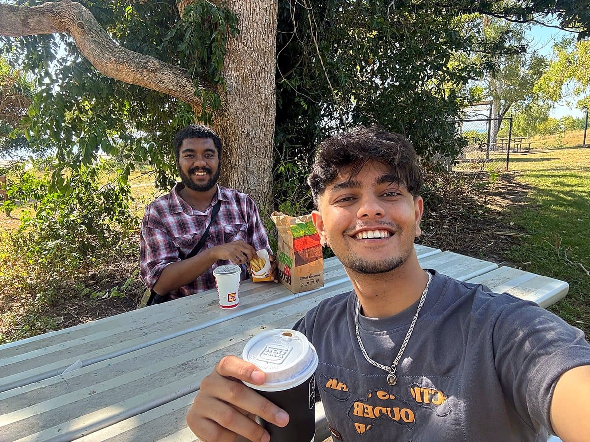 EPNT participants and support workers sharing a picnic in a shady Darwin park