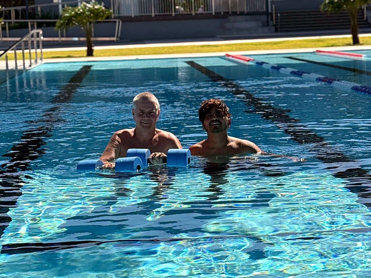 Two EPNT participants laughing in the pool on a community outing